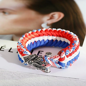 Detailed shot of red white blue paracord bracelet with a vintage silver dragon head toggle