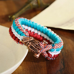 Macro shot of blue and red paracord bracelet with antique copper octopus clasp on wood