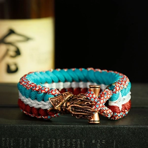 Detailed view of handmade paracord bracelet with red blue white cord and octopus bronze clasp