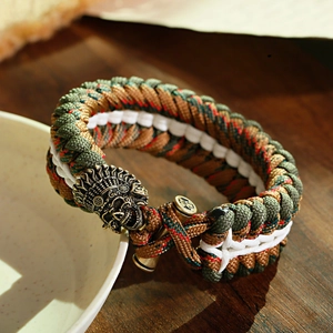Dettaglio del bracciale di sopravvivenza con chiusura a teschio e trama in paracord camo