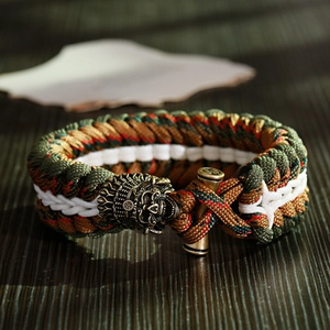 Dettaglio macro del bracciale di sopravvivenza in paracord mimetico con teschio