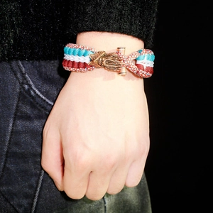 Close-up of tricolor woven paracord bracelet with bronze owl clasp on wrist