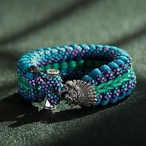Dettaglio di un braccialetto in paracord mimetico con fibbia a forma di teschio d'argento