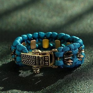 Gros plan d'un bracelet de survie en paracorde tressée sarcelle avec boucle en bronze