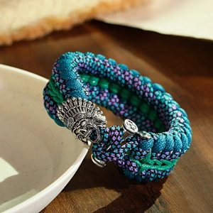 Dettaglio macro del braccialetto in paracord blu pavone con ciondolo a forma di teschio