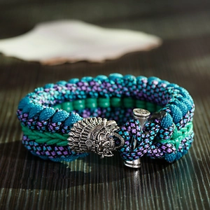 Vista dettagliata del bracciale in paracord mimetico blu con fibbia in metallo a teschio