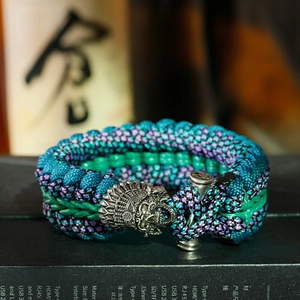 Dettaglio macro della chiusura a teschio su bracciale survival in paracord