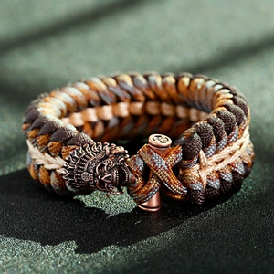 Dettaglio del bracciale survival in paracord con teschio in bronzo e chiusura totem
