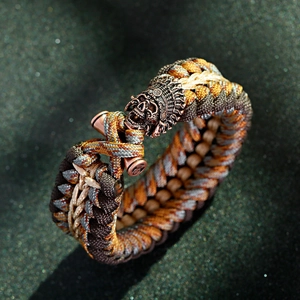 Dettaglio del bracciale in paracord mimetico con teschio in bronzo e trama intrecciata