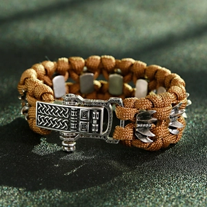 Détail macro d'un bracelet de survie tressé avec boucle en métal et motif nordique