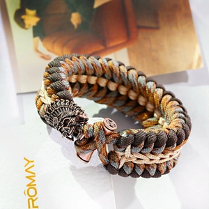 Dettaglio macro del bracciale survival in paracord con teschio tribal e trama intrecciata