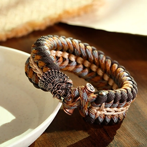 Dettaglio del braccialetto di sopravvivenza in paracord con fibbia a teschio in bronzo