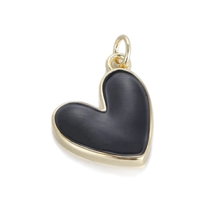 Detalle macro del colgante de corazón en esmalte negro con marco de metal dorado