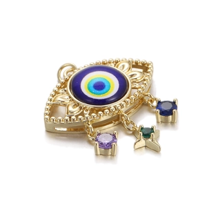 Macro detail of 14K gold plated Evil Eye charm with vibrant zircon stone pendants