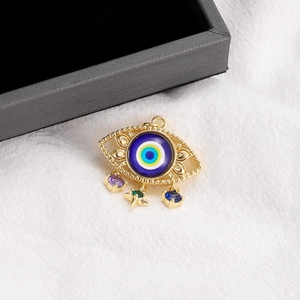 14K gold plated evil eye pendant with colorful gemstones on a white textured background