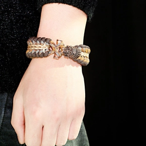 Dettaglio della chiusura a testa di drago in bronzo e bracciale in paracord intrecciato