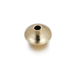 Macro shot of polished gold rondelle spacer bead with center hole for DIY jewelry
