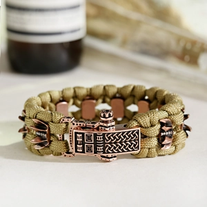 Gros plan du bracelet de survie en paracorde kaki avec boucle en bronze gravée