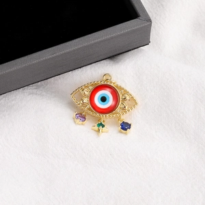 Macro detail of 14K gold plated evil eye pendant with colorful teardrop gemstones