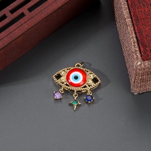 Detail of 14K gold plated evil eye pendant with colorful gemstone charms on grey texture