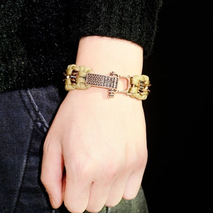 Détail d'un bracelet paracorde vert militaire avec boucle en métal bronze antique et pointes