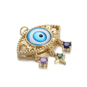 Detail of 14K gold plated evil eye pendant with blue resin and colorful crystal drops