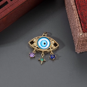 Detail of 14K gold plated evil eye pendant with colorful gemstones on a dark surface