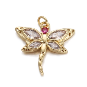 Macro view of a gold dragonfly pendant with marquise-cut zircons and red gemstone accent
