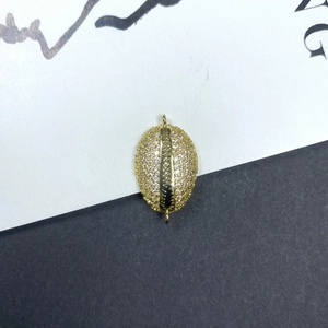 Vista macro de colgante de grano de café dorado con circonitas para joyería DIY