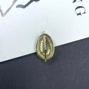 Vista detallada de un colgante de concha dorada con anillos dobles para creación de joyería DIY