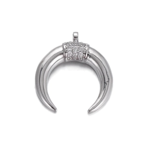 Macro shot of silver crescent pendant with micro-pave white zircon stones for jewelry making