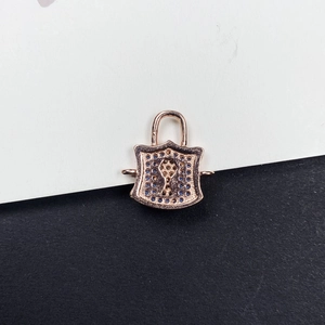 Dettaglio del ciondolo a scudo in oro rosa con micro-pave di cristalli blu e serratura