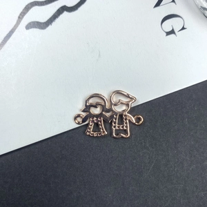 Détail d'un pendentif de famille en or 14K avec finition or rose et petites pierres rouges