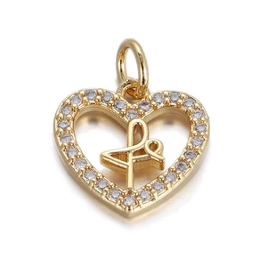 Dettaglio pendente a cuore dorato con zirconi e design con albero della vita