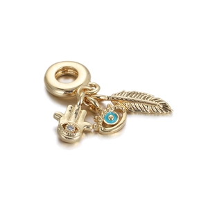 Detailansicht der vergoldeten Hamsa-Hand, blaues Auge und Feder-Anhänger mit Zirkonia