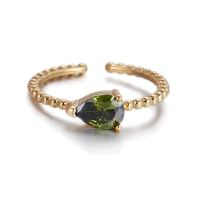Vista macro de anillo dorado trenzado con circonita verde oliva en talla de pera
