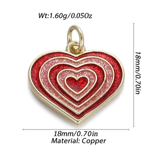 Detail of 14K gold plated heart pendant with red glitter inlay and copper base