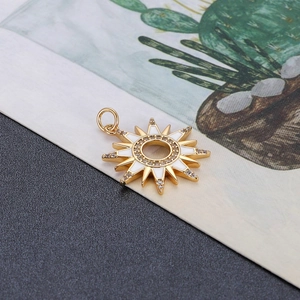 Detail van een goudkleurige zonnehanger met wit emaille en fonkelende zirkonia steentjes
