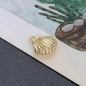 Detailweergave van een gouden schelphanger met gepolijste metalen oppervlakteafwerking