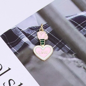 Macro detail of 14K gold-plated heart pendant with enamel rose and LOVE engraving