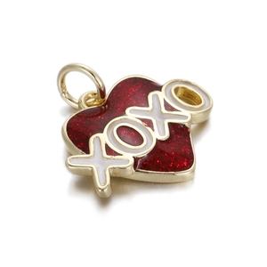 Macro shot of 14K gold plated heart pendant with red glitter enamel and XOXO lettering