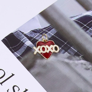 Macro view of 14K gold plated heart pendant with red glitter enamel and XOXO engraving