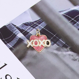 Detail of pink glitter heart pendant with XOXO letters and golden metal edges