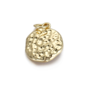 Macro-opname van een gouden ronde hanger met gehamerde textuur en metalen ring