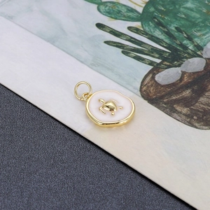 Macro-opname van een vergulde schildpad hanger met wit emaille voor het maken van sieraden
