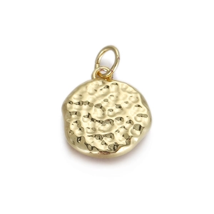 Macro-opname van ronde gouden hanger met gehamerde textuur voor DIY-sieraden maken