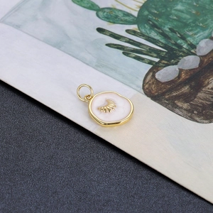 Detailopname van roze emaille hanger met gouden zonreliëf en gepolijste legering afwerking