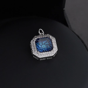 Makro-Detail von achteckigem vergoldetem Anhänger mit blauem Stein und Zirkon