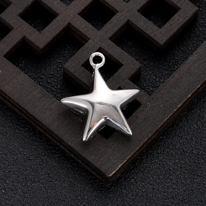 Macro view of a star-shaped silver-plated metal pendant with high-polish mirror finish