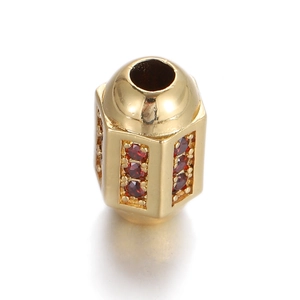 Détail du pendentif cylindrique plaqué or avec zircons rouges et trous de perforation